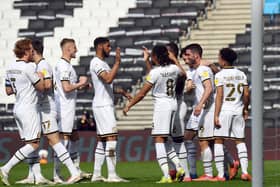 Dons celebrate with Will Grigg after he scored his fourth