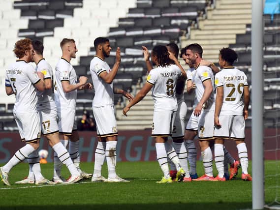 Dons celebrate with Will Grigg after he scored his fourth