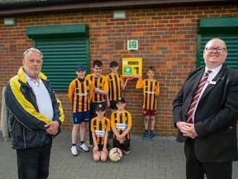 Ian Lawson, chairman of Hanslope Hornets Football Club, and Alan Hames, sales manager for Davidsons Homes, with footballers from the club