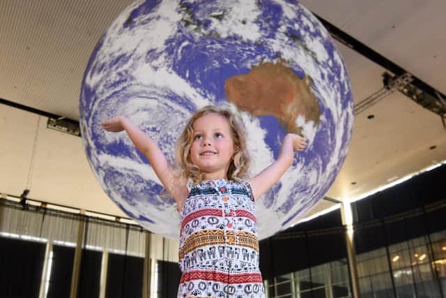 Five-year-old Amelie looks up at Gaia art installation by Luke Jerram, on display at centre:mk