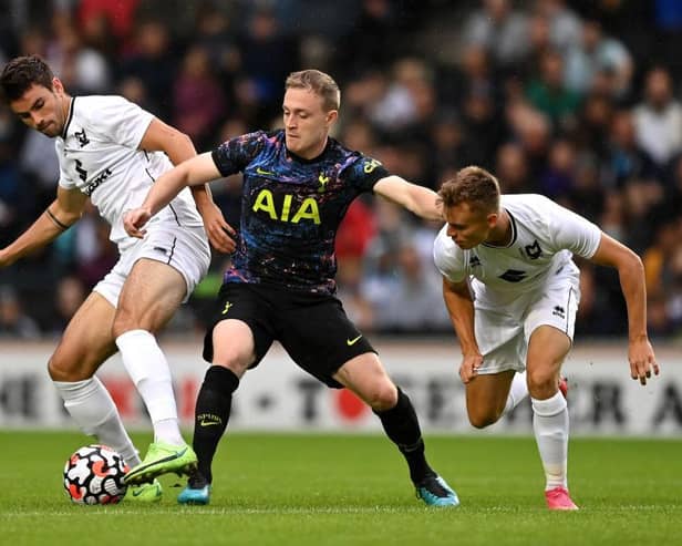 Spurs' Oliver Skipp is challenged by MK Dons pair Matt O'Riley and Scott Twine