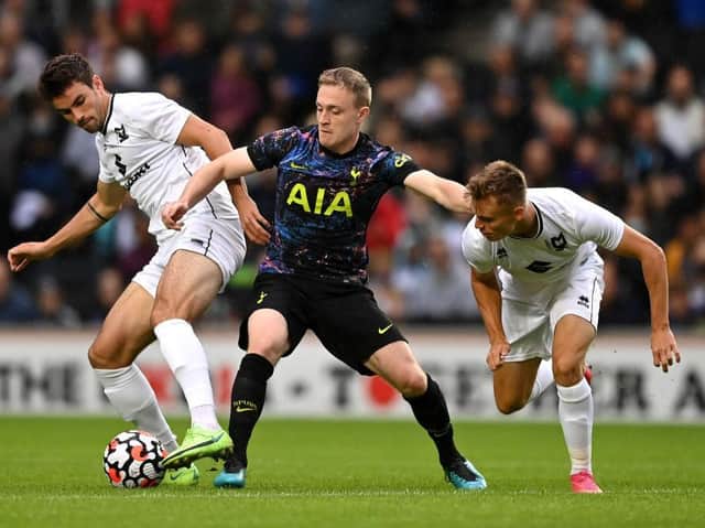 Spurs' Oliver Skipp is challenged by MK Dons pair Matt O'Riley and Scott Twine