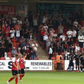 MK Dons' players and fans celebrate Hiram Boateng's late equaliser at Cheltenham Town on Saturday