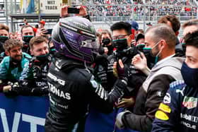 Lewis Hamilton celebrates with his Mercedes team after winning his 100th race