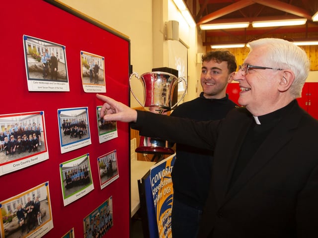 Fr. Colum Clerkin discussing some old sports photos with former pupil and Steelstown All Ireland winner, Cahir McMonagle, at last week's event in Hollybush Primary School. (Photo: Jim McCafferty)