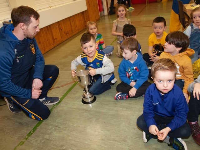 Steelstown captain Neil Forester showing off the Brian Ogs' trophies to some of the younger pupils at Hollybush Primary School. (Photo: Jim McCafferty)