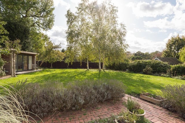 The extensive gardens feature a lavender path under the rose arch leading to an outdoor office, well stocked borers three beautiful silver birches