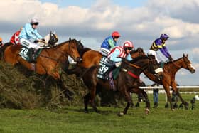 Corach Rambler (far side) jumps one of Aintree's famous fences, The Chair, on his way to victory in last year's Grand National.