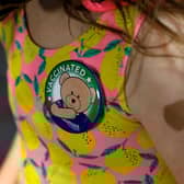 A child wears a 'vaccinated' badge (Photo by JEFF KOWALSKY/AFP via Getty Images)