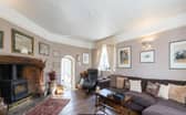 The living room in the property, complete with luxurious comfortable sofas and a wood burning fire.