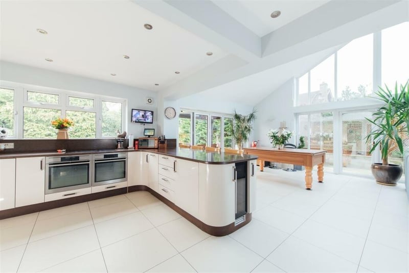 The stylish kitchen units include a pull-out larder and bin cupboard. The remainder of the space is a large open plan dining room and family room with a stunning high vaulted ceiling with feature floor to apex glazing and skylight windows.