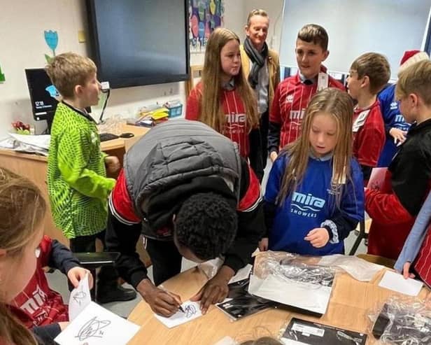 Children wearing football shirts donated through the Kitmas appeal