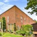 The house is a corner terrace on an L-shaped plot