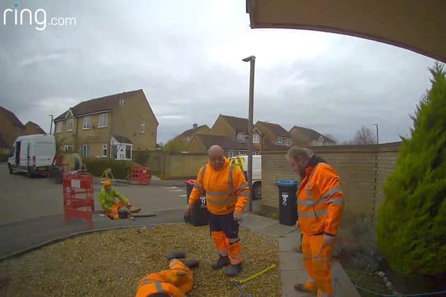 Video grab of a group of workmen losing a tug of war with a a drain in Milton Keynes, Bucks.  Credit: Laura Staunton / SWNS