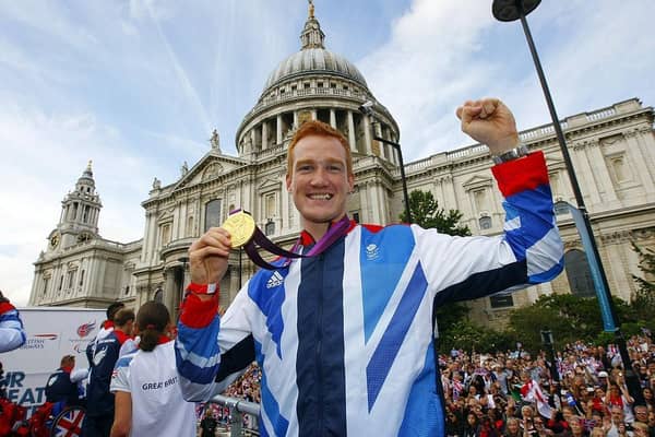British Olympic gold medal winning athlete Greg Rutherford holds his long jump gold medal as he takes part in the parade passing St Paul's Cathedral during the London 2012 Victory Parade for Team GB.