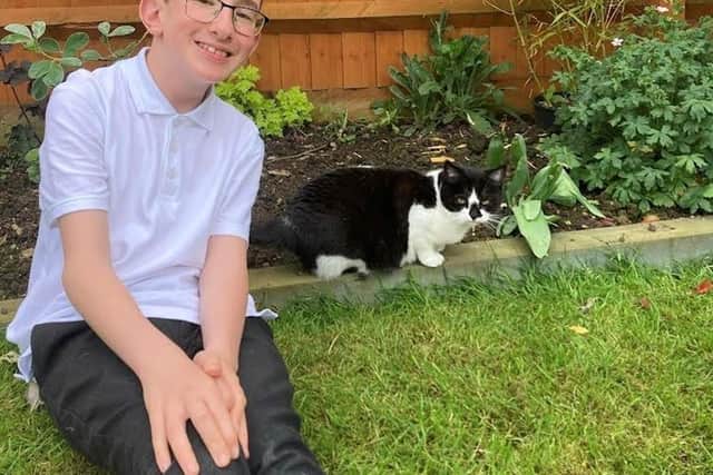 Alex pictured in the garden with his new cat Coco