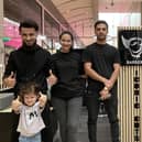 Sophia is pictured (right) with her little sister Alexandra and the team from Iconic Cuts barbers in Milton Keynes