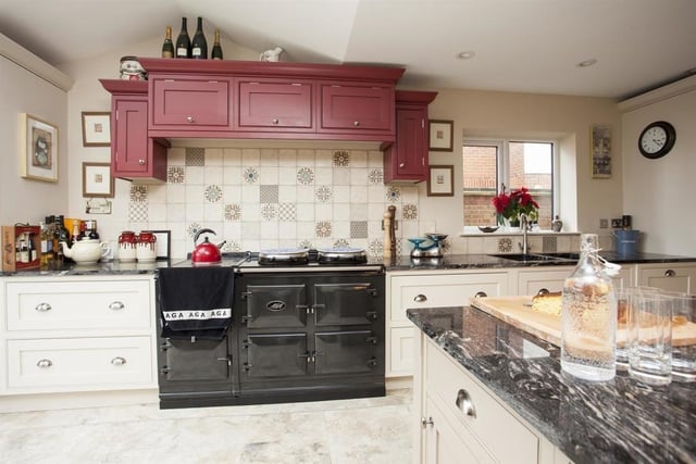 The kitchen comprises dual control Aga with integrated appliances include dishwasher, larder fridge and a tall freezer. The central island unit has cupboards, drawers and shelving and a granite worktop.