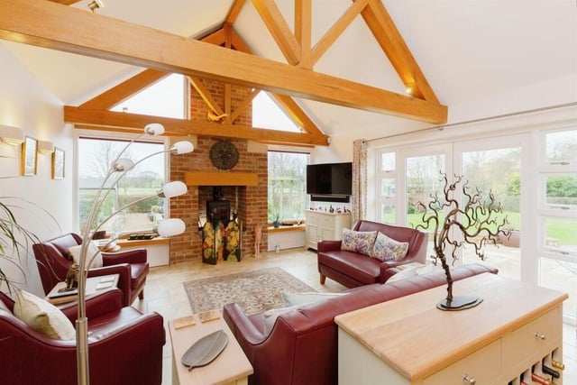 The vaulted ceiling with aged oak beams and feature lights is one of this property's stand out features with log burner providing an impressive focal point and views over the garden and countryside beyond.