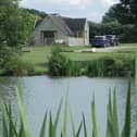 The Skylark Lodge at Brook Meadow viewed from across the campsite's five-acre fishing lake