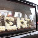 The horse-drawn hearse was adorned with many floral tributes including this one spelling her name