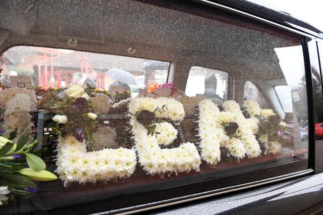The horse-drawn hearse was adorned with many floral tributes including this one spelling her name