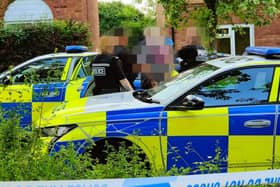 Police carrying out the arrest in Two Mile Ash of a man suspected of carrying a firearm. The man's photo has been blurred for legal reasons