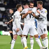 MK Dons celebrate Bradley Johnson's opening goal against Port Vale on Tuesday night. While Dons' performance wasn't their best of the season, it resulted in their first win of the campaign