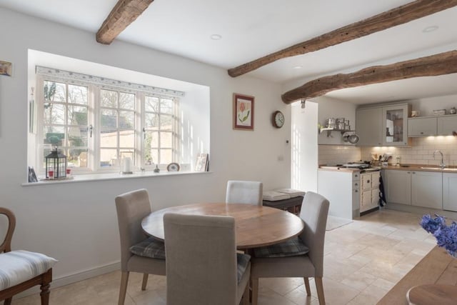 The dining and utility room  are located with within the  kitchen area with feature exposed beams and view across the courtyard