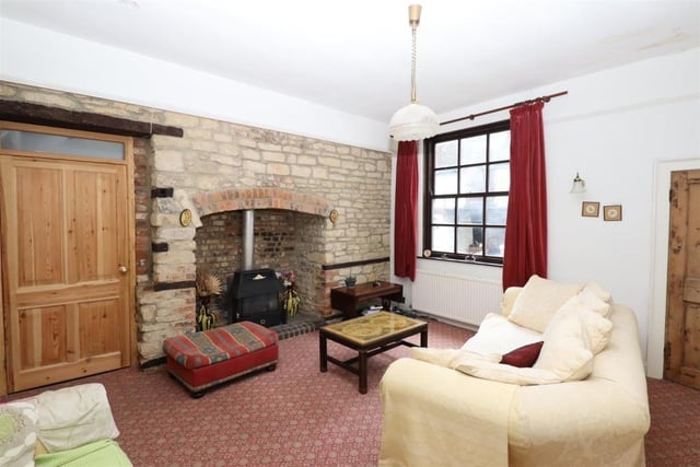 The living room has a fireplace with exposed brick chimney breast and coal effect gas fire, plus sliding sash window with period window shutters