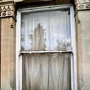 The window to Pauly's flat shows the damp and mould
