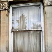 The window to Pauly's flat shows the damp and mould