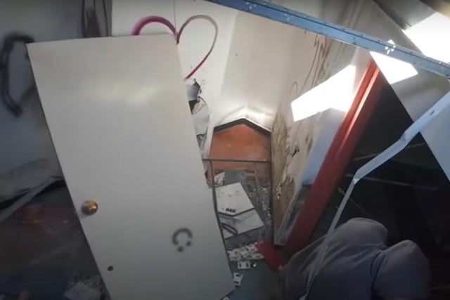 A door hangs sadly off the wall
