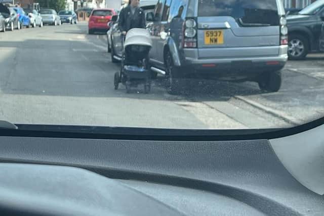 This photo, taken four hours before the fire, shows a woman having to push her pram in the road due to the illegally parked row of cars blocking the pavement in Tavistock Street
