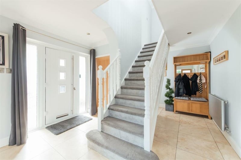 The front door opens to the hall, which has a tiled floor, stairs to the first floor, two cupboards and doors to all rooms, including French doors to the kitchen.