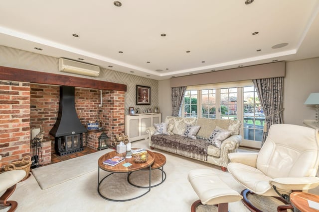 The spacious lounge boasts a feature fireplace and French doors opening on to the garden space