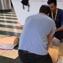 A shopper learns how to perform CPR on a dummy