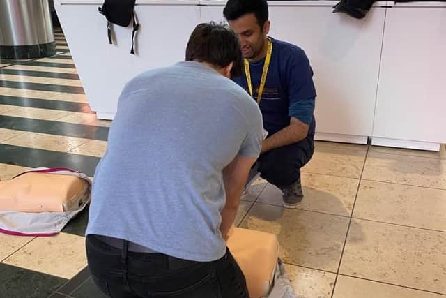 A shopper learns how to perform CPR on a dummy