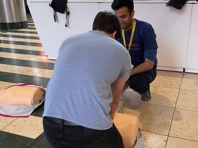 A shopper learns how to perform CPR on a dummy