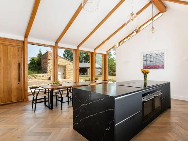 A contemporary kitchen/breakfast room flaunts a modern central island, stone worktops and bespoke units. Photo: Fisher German LLP - South/ Zoopla