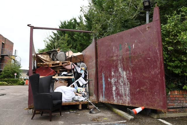 The skip is piled high with discarded furniture and bric a brac