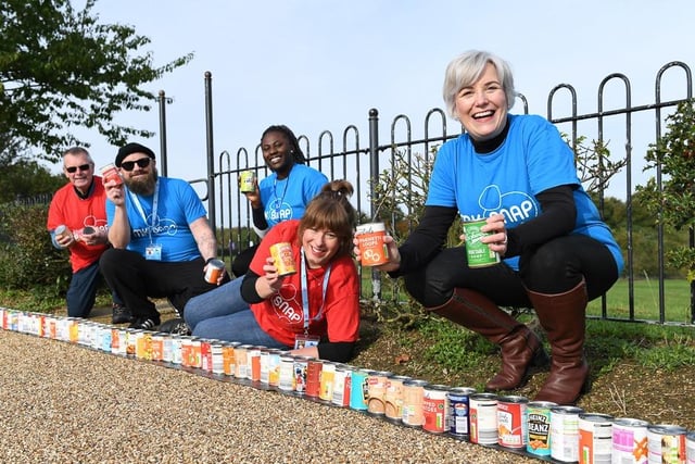 Volunteers from MK Snap display their line-up of cans