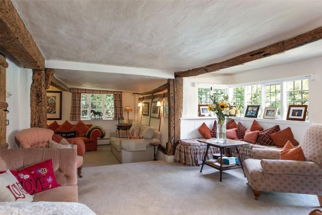 The sitting room has exposed ceiling beams and wall timbers. There is a window seat and fireplace with cast iron log burning stove.