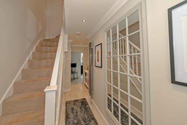 The light and airy entrance hall  features stairs to first floor landing with cupboard under,  and a radiator