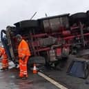 Emergency services said the driver walked away with "just a few scratches" after this lorry crashed overturned and crashed into a concrete barrier on the M1