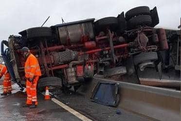 Emergency services said the driver walked away with "just a few scratches" after this lorry crashed overturned and crashed into a concrete barrier on the M1