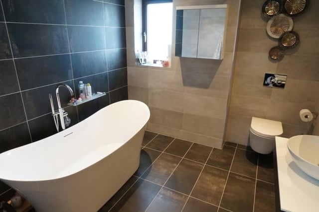The  family bathroom features sanity sink unit, low level WC, free standing bath with mixer tap over and shower attached, chrome heated towel radiator, fully tiled walls and floor, extractor fan.