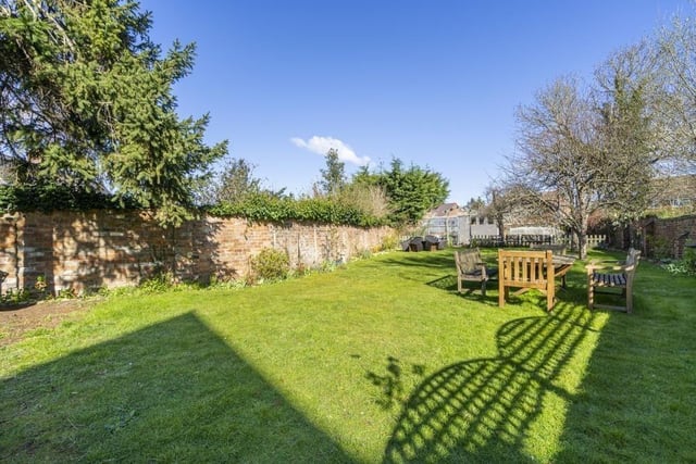 The rear garden features large lawn with established trees and shrubs