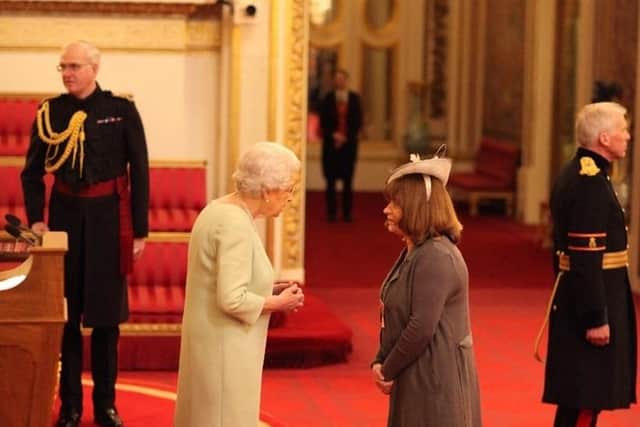 Sue Farrington Smith being given her MBE in 2017 by Queen Elizabeth II