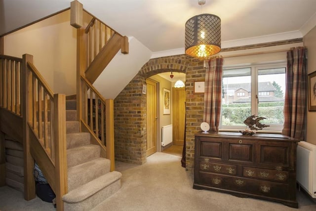 An oak dog-leg staircase leads to the first floor and a decorative exposed brick archway.
